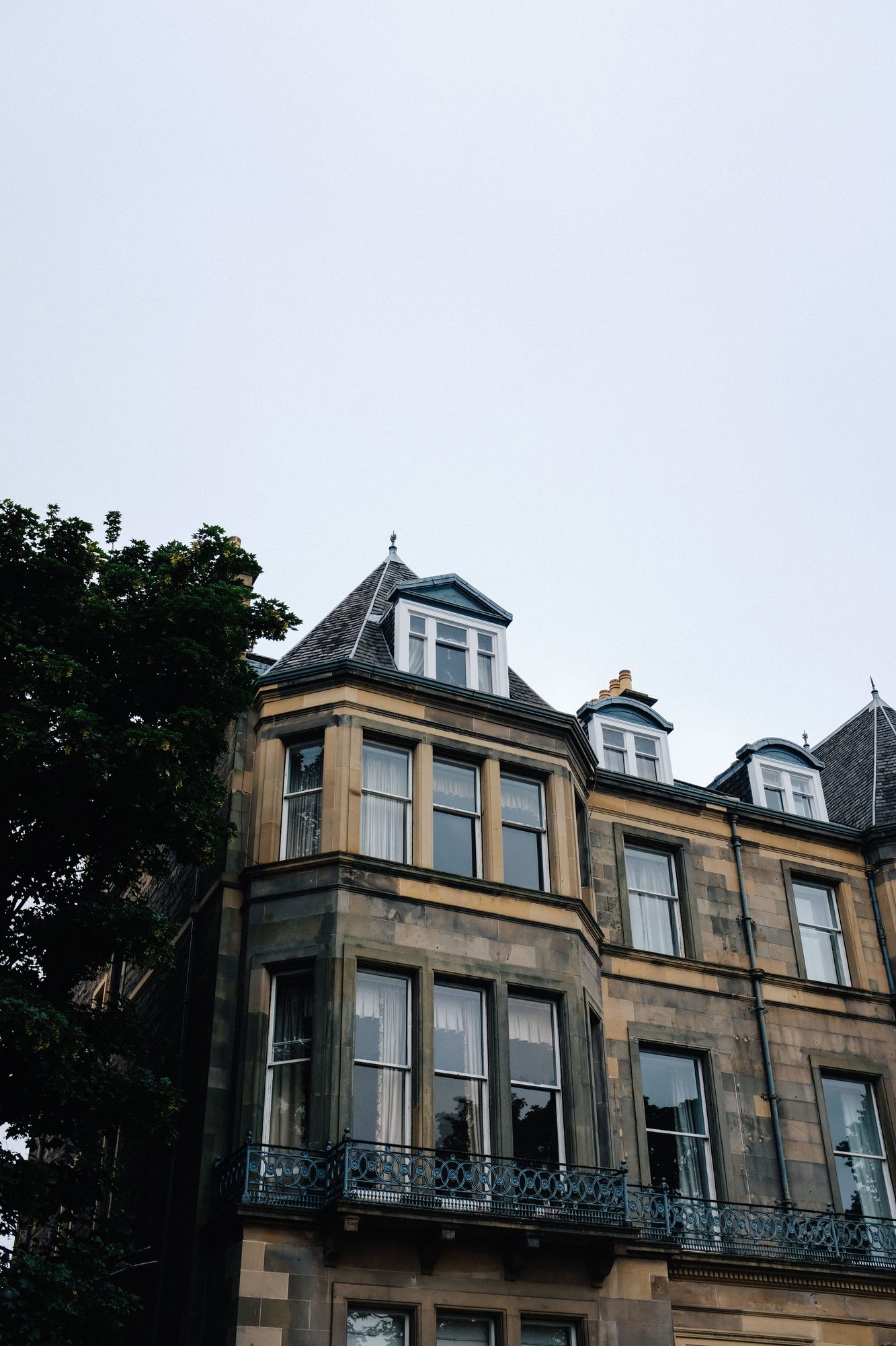 A grand New Town Edinburgh townhouse with a slate dormer roof and ornate iron balconies